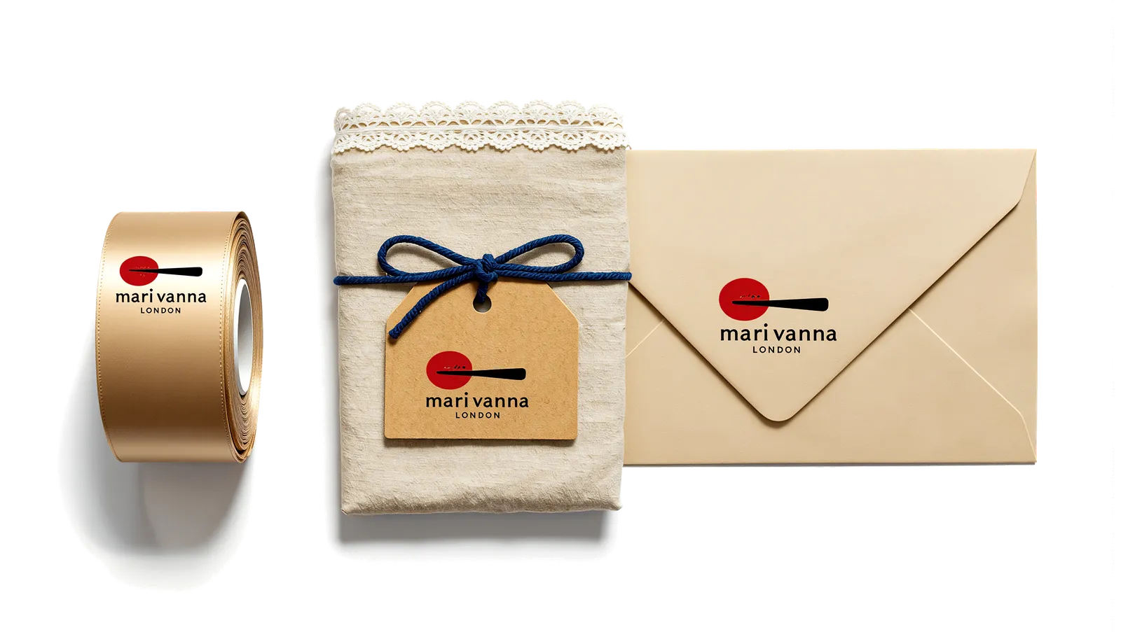 House gift wrapping — spoon-printed ribbon, lace-edged paper with a name tag, and a gift certificate envelope